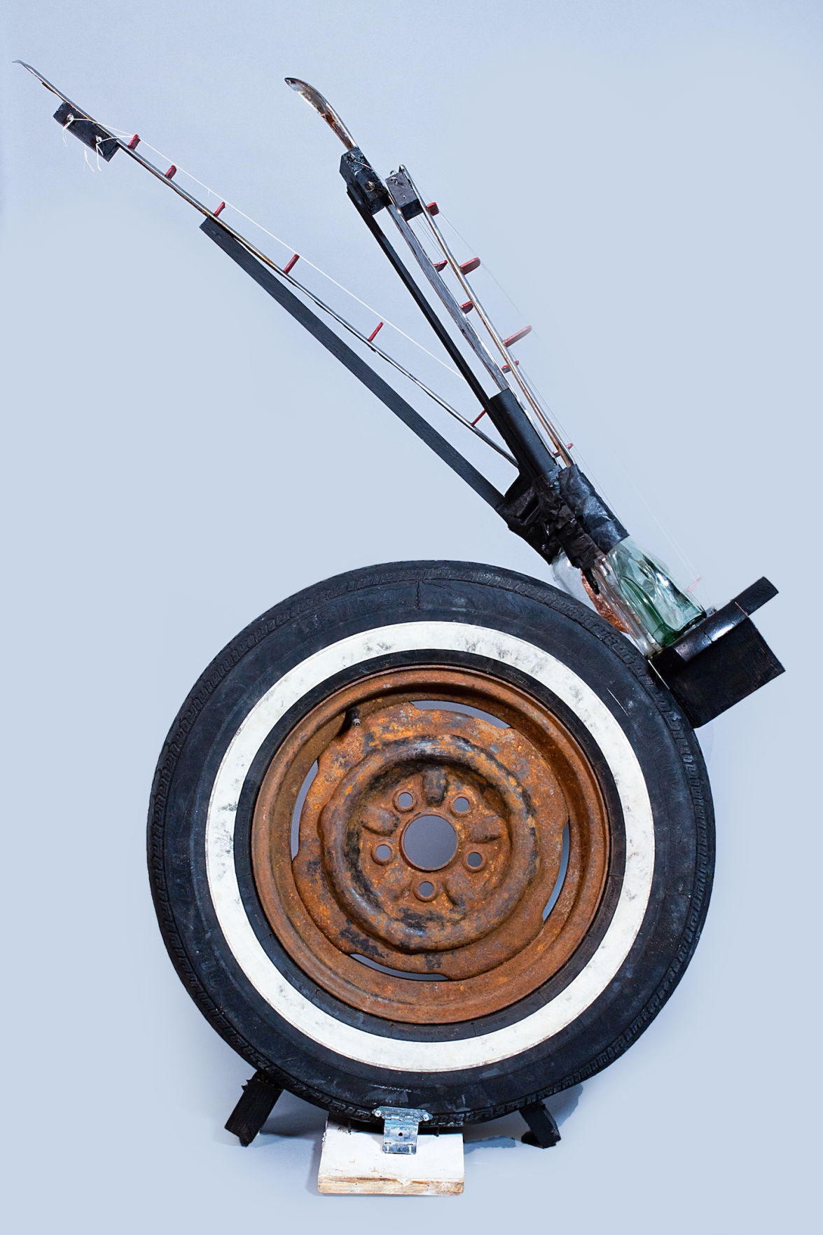 An instrument called a "ziggy" lies on the ground. It is made from a white wall tire found in the Kansas river